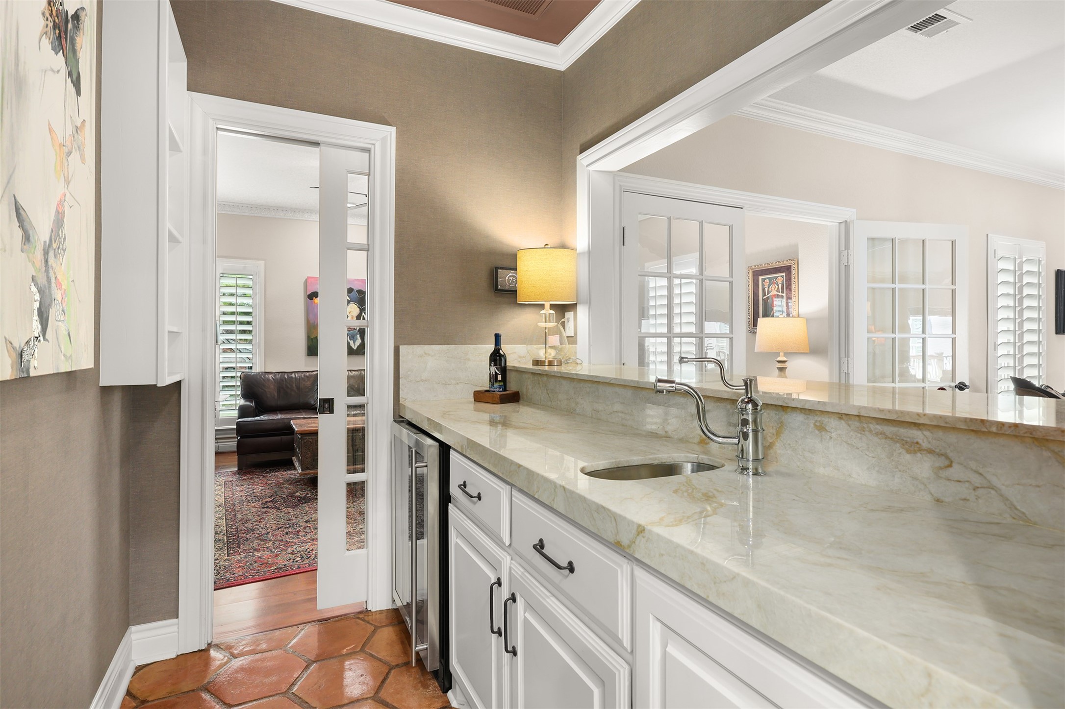 View from the kitchen into the wet bar, featuring a charming French-style pocket door that can be closed for privacy or left open for easy access to the television room.
