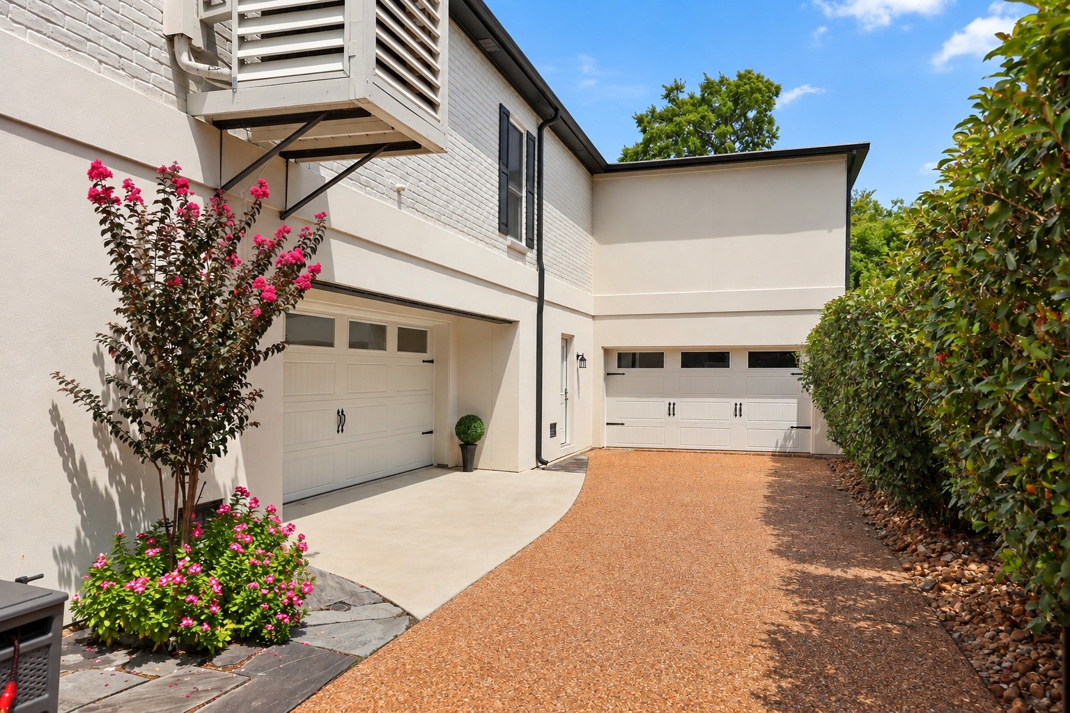 Expansive driveway leads to abundant covered parking and storage beneath the elevated home. Garage access is located to the left, with additional open parking straight ahead. The area beneath the pool house provides exceptional storage space, allowing the main covered area beneath the home to remain open, spacious, and versatile.