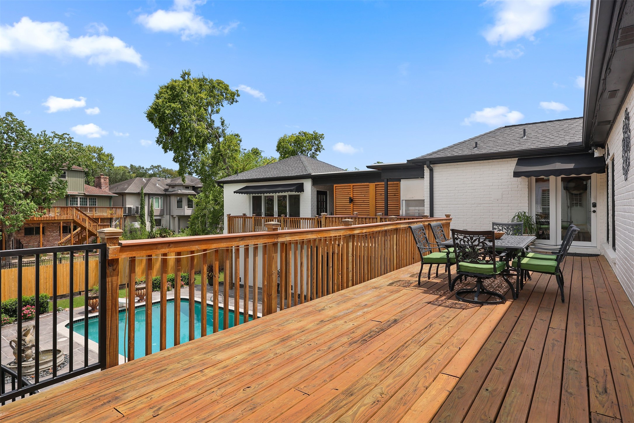Spacious elevated deck with convenient access from both the kitchen and hallway near the primary suite. Overlooking the sparkling pool and backyard, this inviting outdoor living space is perfect for dining, relaxing, and entertaining. A charming spiral staircase provides direct access to the pool area below.