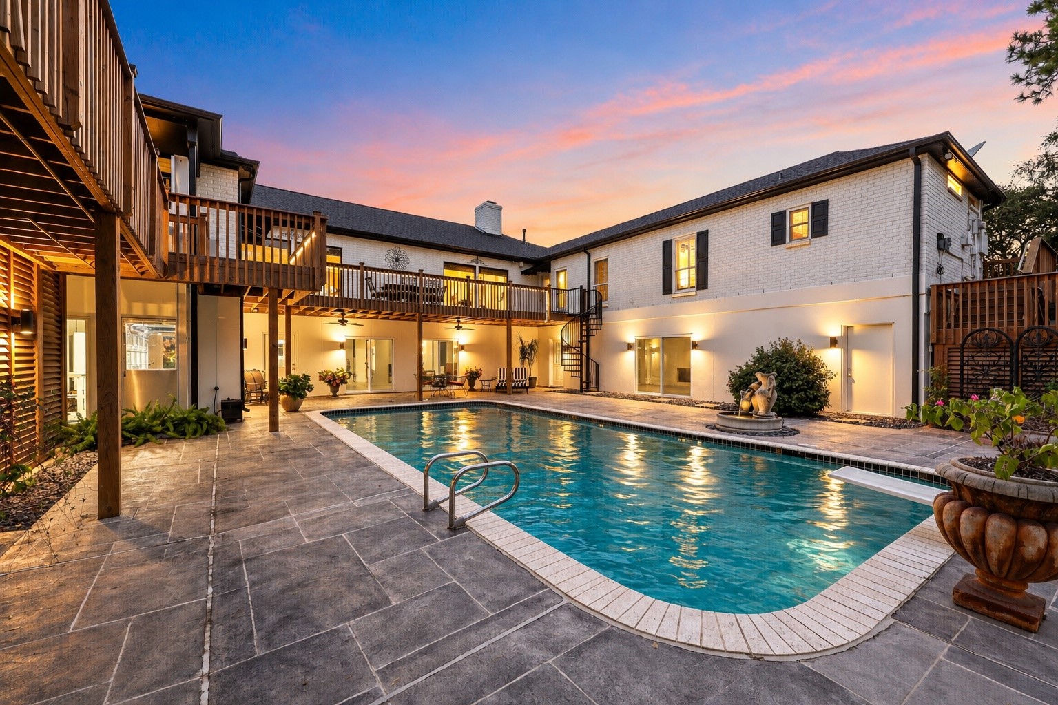 Beautiful accent lighting illuminates the pool and courtyard, highlighting the custom architectural louvers with dramatic up-and-down lighting, while decorative louvered screening cleverly conceals the pool equipment.