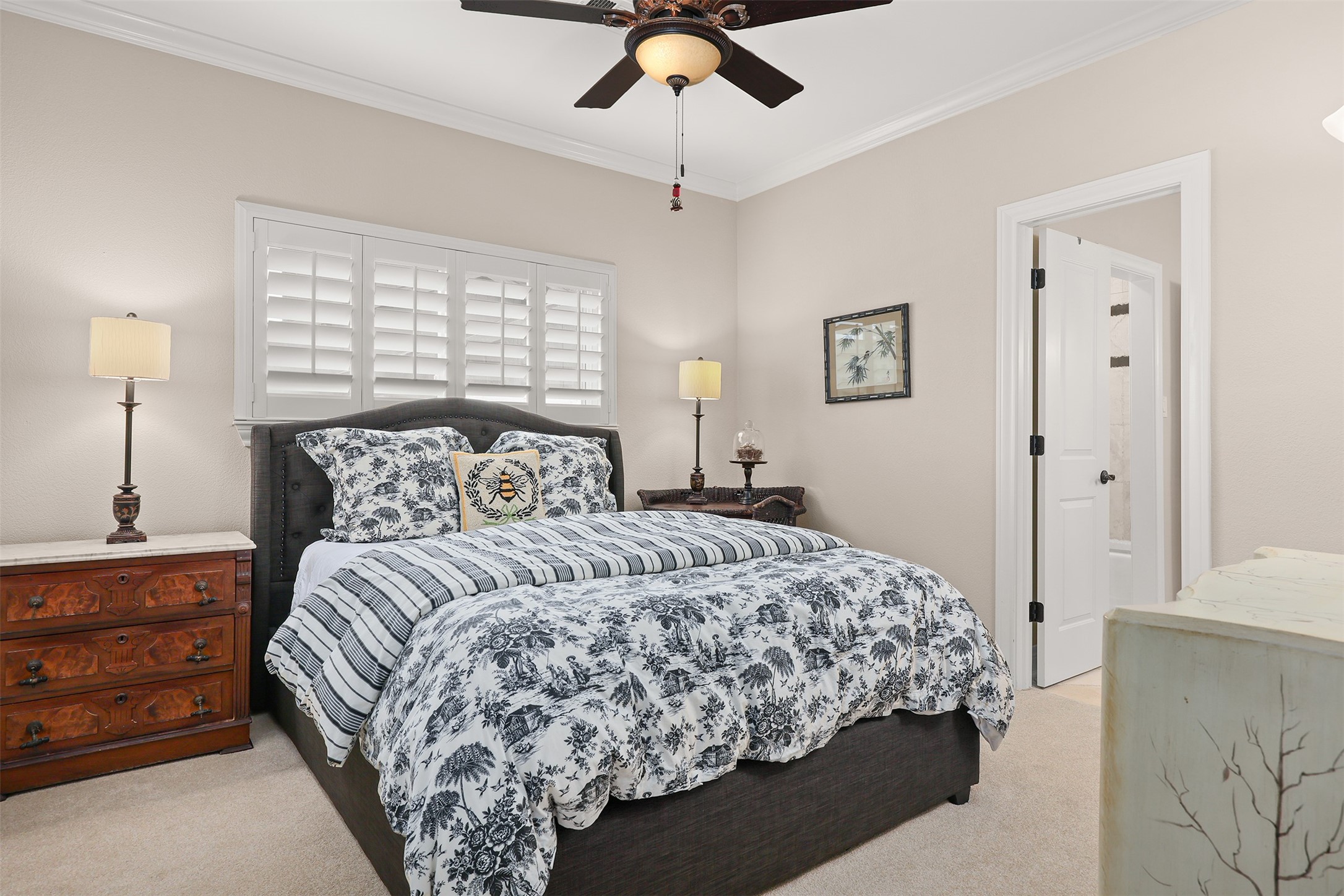 Spacious bedroom #2 features beautiful plantation shutters and access to a generously sized bathroom with 36-inch high cabinetry, abundant built-in storage, and ample counter space for guests to comfortably spread out and feel at home. The bathroom also connects to bedroom #3, currently used as a home office, offering a convenient and versatile shared-bath arrangement.