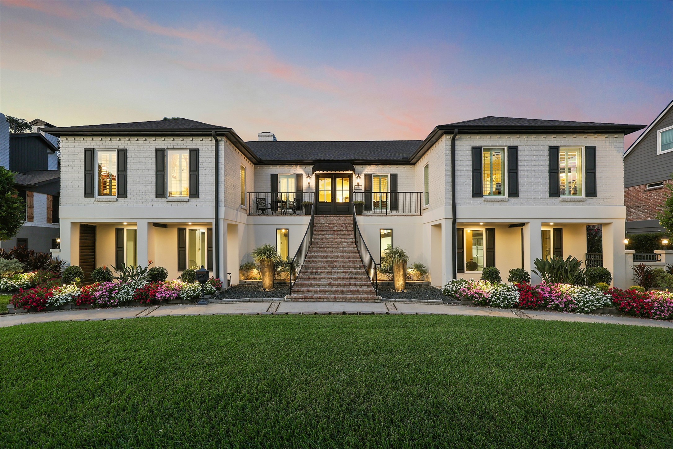 Stunning curb appeal! This beautifully designed custom home welcomes you with an impressive Old Chicago-style brick staircase, elegant architectural details, classic shutters, and lush, professionally landscaped grounds.