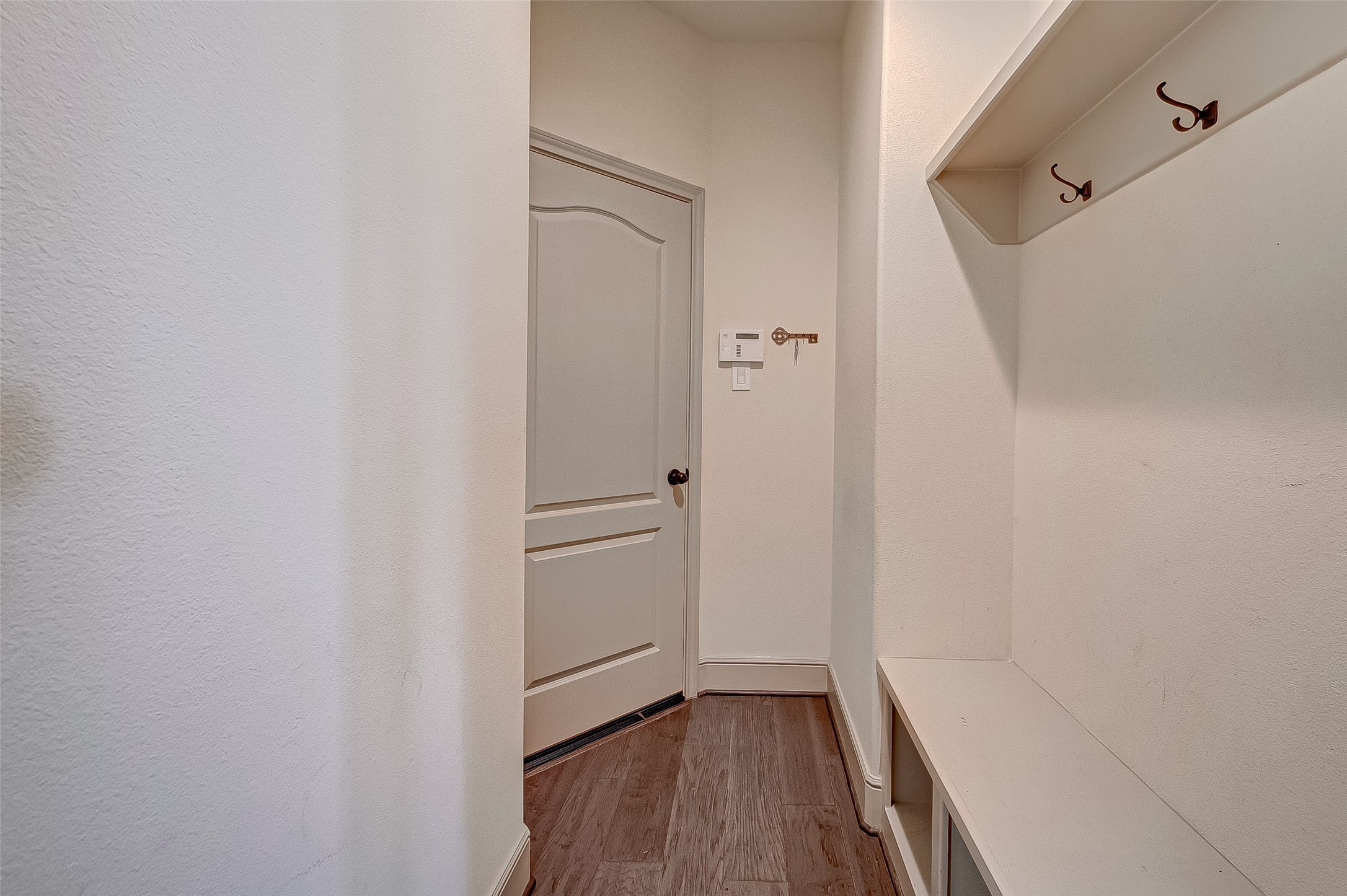 The neutral color palette enhances the mud room's welcoming and functional ambiance.
