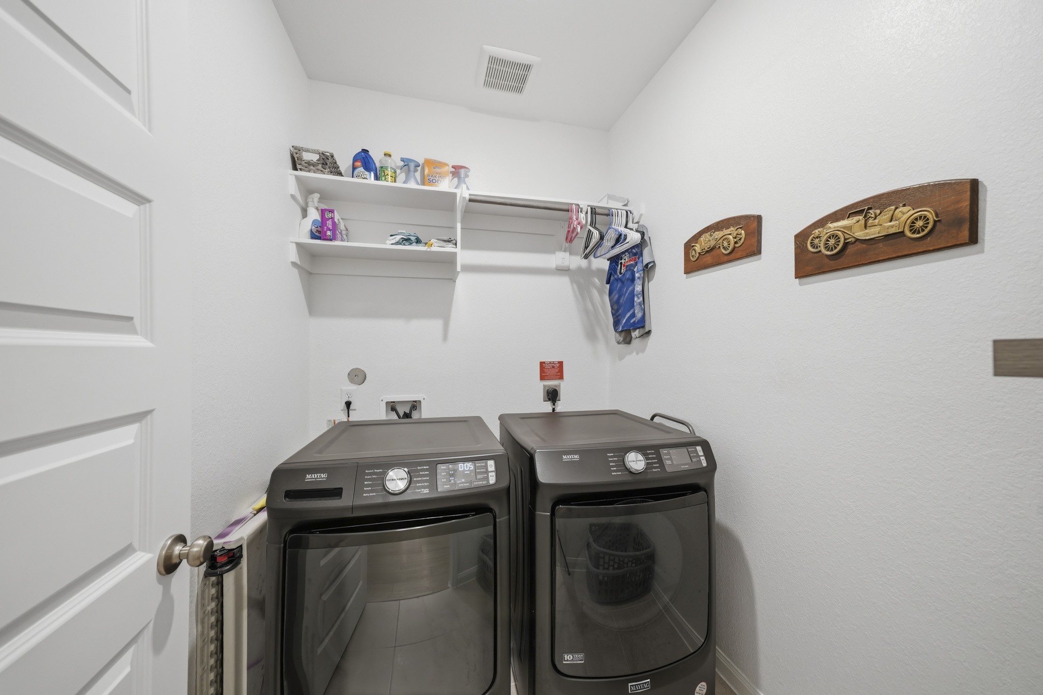 Modern laundry room with ample shelving and hanging space for convenience.