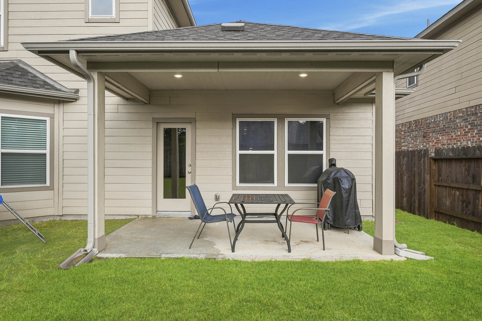 Charming covered patio with ample seating space, perfect for outdoor entertaining and relaxation.