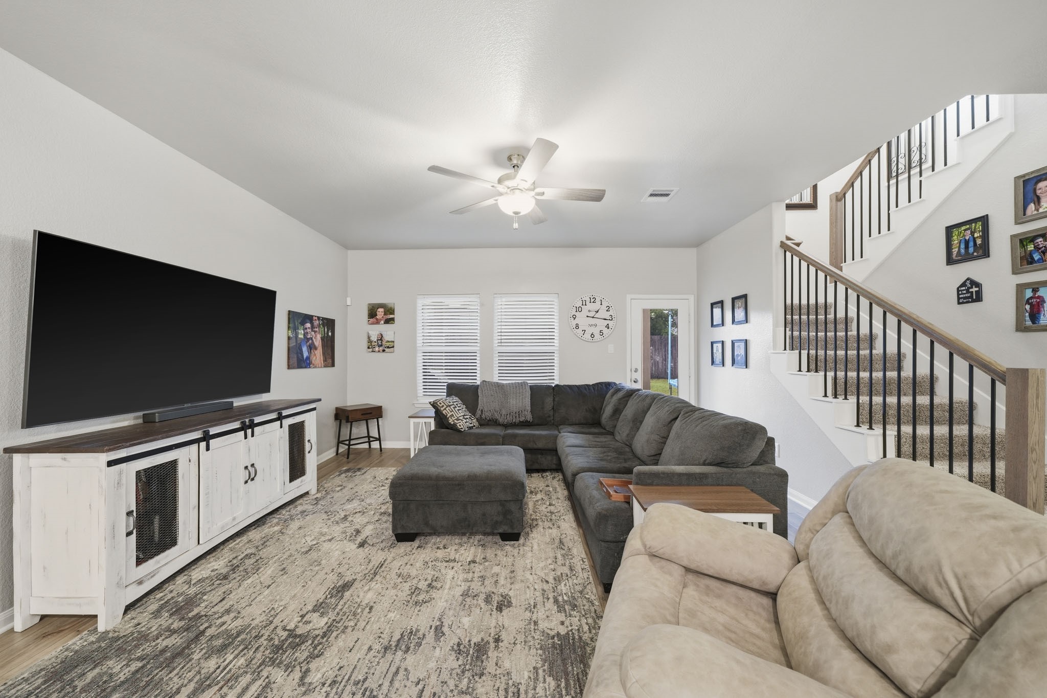 Spacious living room, large enough for this oversized sectional sofa, and elegant staircase, perfect for family gatherings and relaxation.