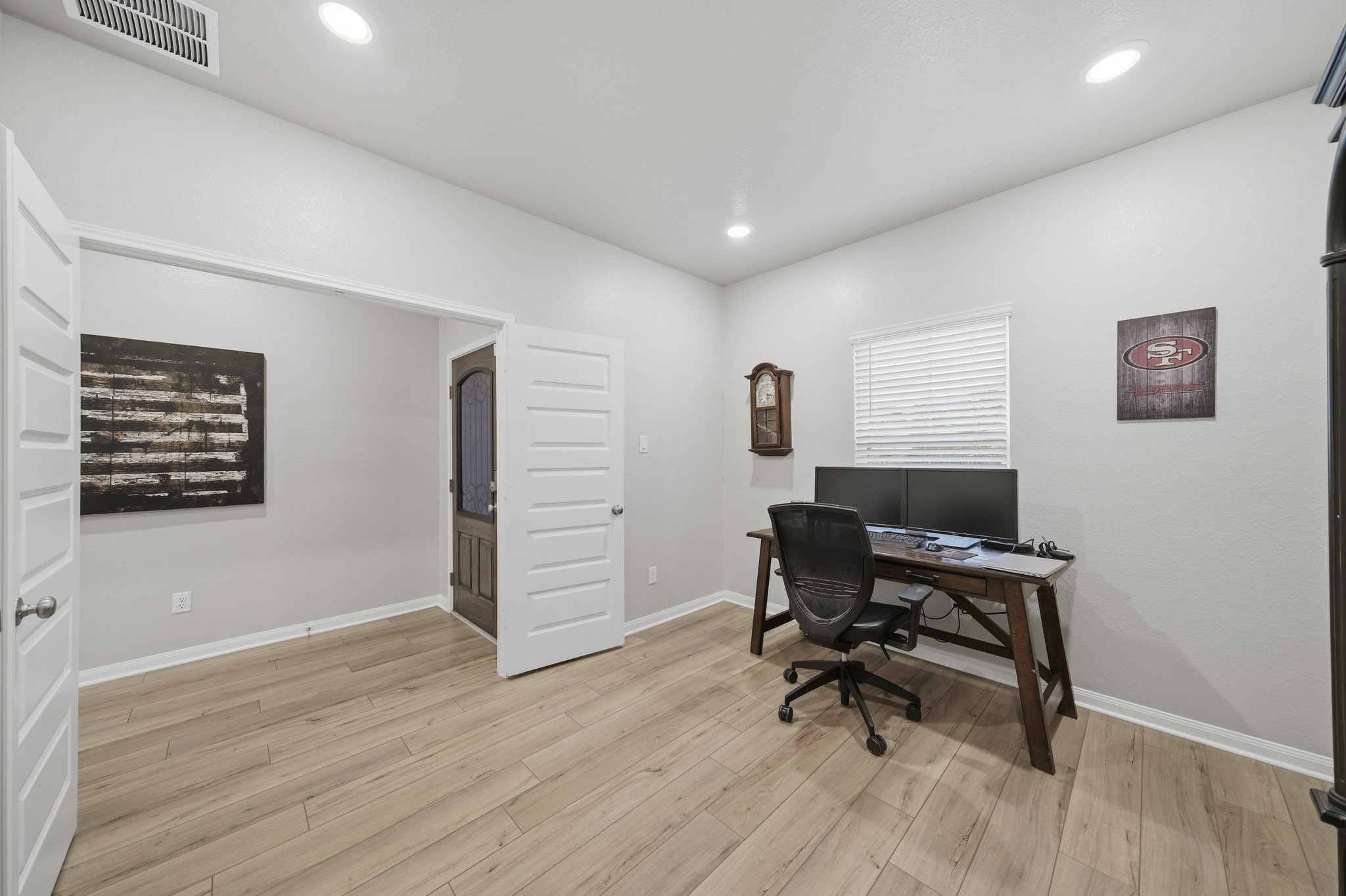 Bright and versatile office space with sleek floors, recessed lighting, and a spacious desk area perfect for productivity.