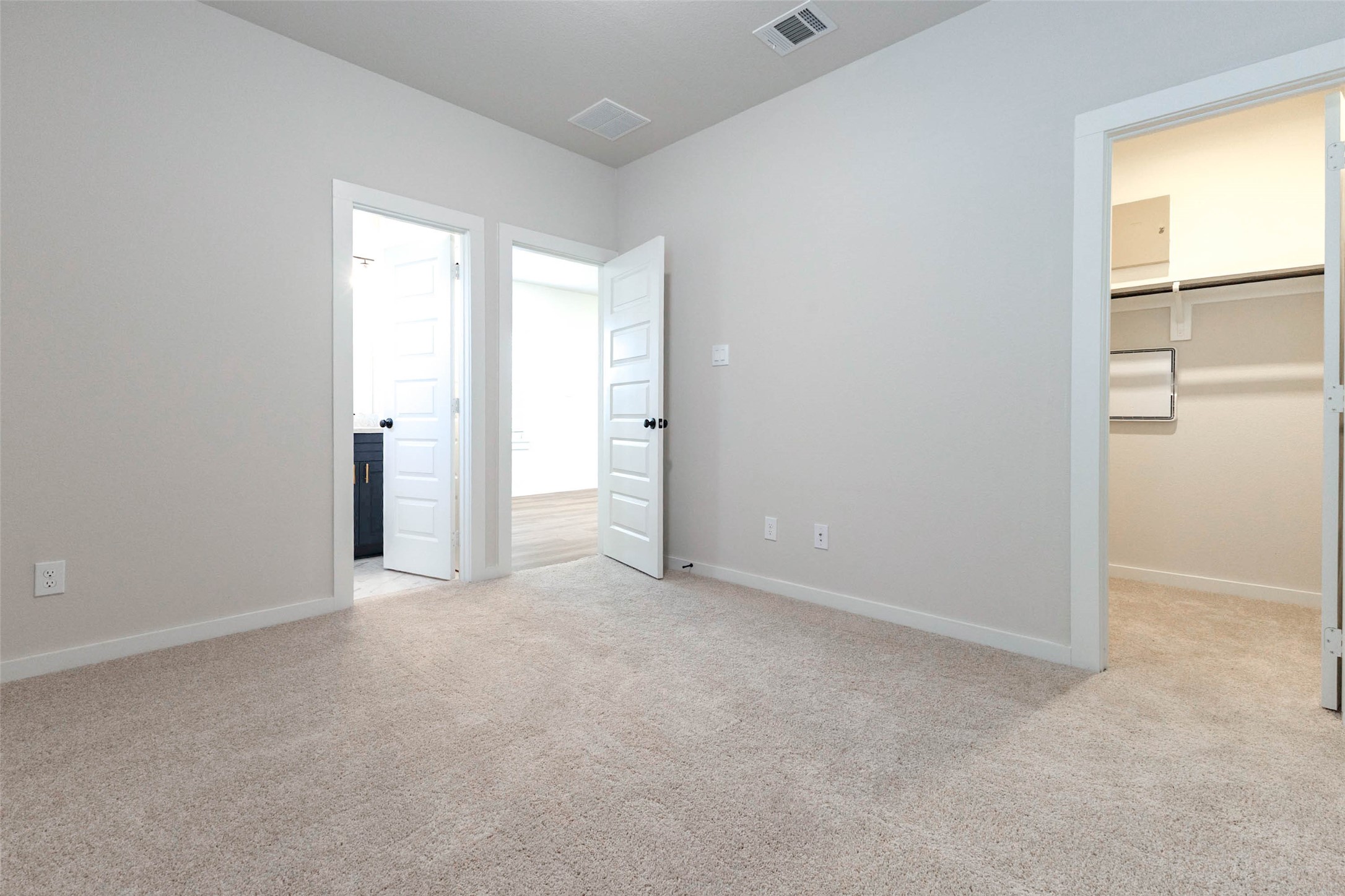 This carpeted bedroom feels bright and quiet, with soft neutral walls that work with any bedding or furniture. Two doors lead to an adjoining bath and a walk-in closet, making it a flexible fit for a guest room, a home office or a bedroom for a family member who wants privacy and plenty of storage. Fresh paint and plush carpet are ready for the first move-in.