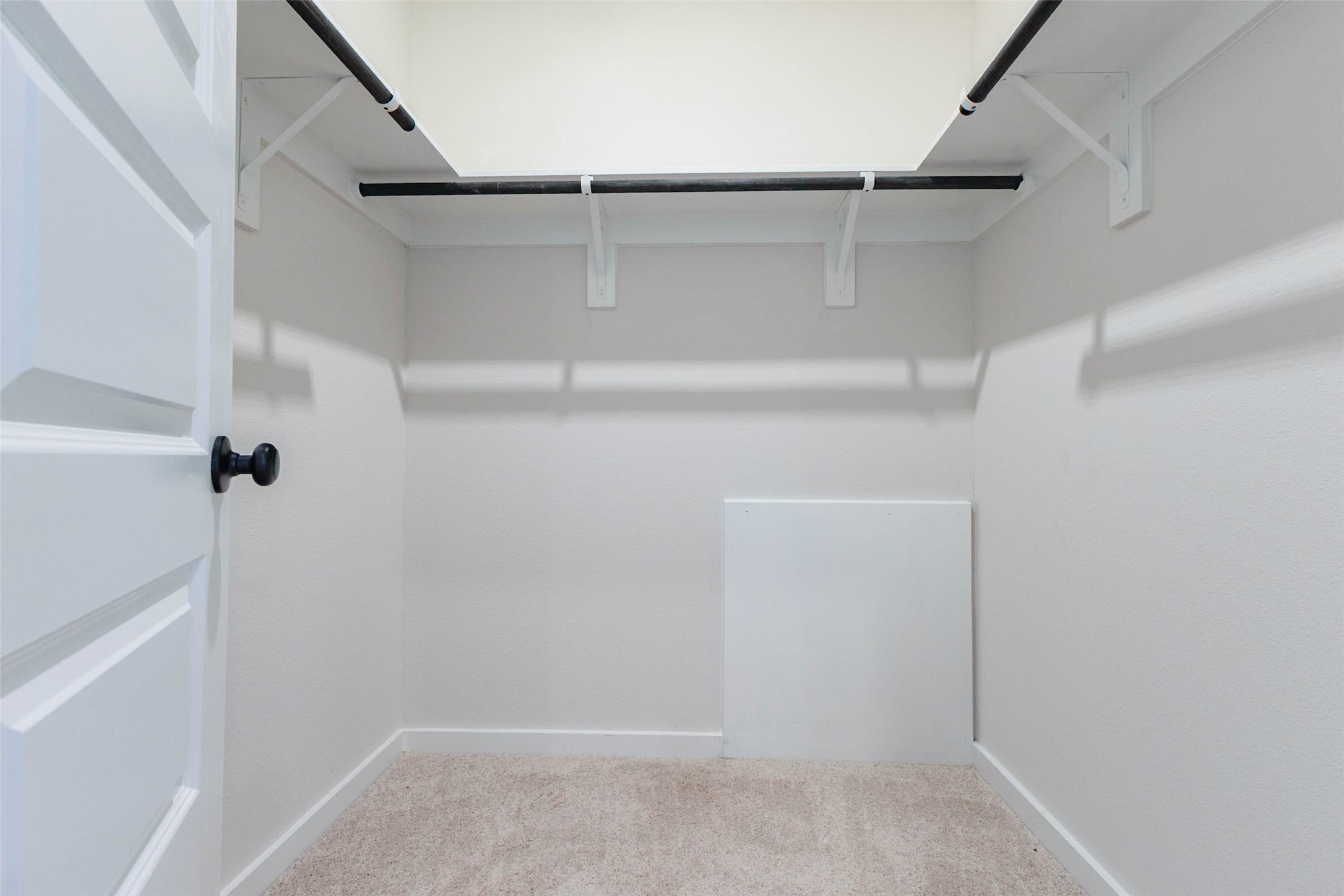 Step into the primary walk-in closet, with a double hanging rod, a top shelf and room along the walls for dressers or shoe racks. The soft carpet and bright, even lighting make it easy to organize seasonal clothes and still find your favorite outfit in a hurry. Closet space like this is a major daily convenience.