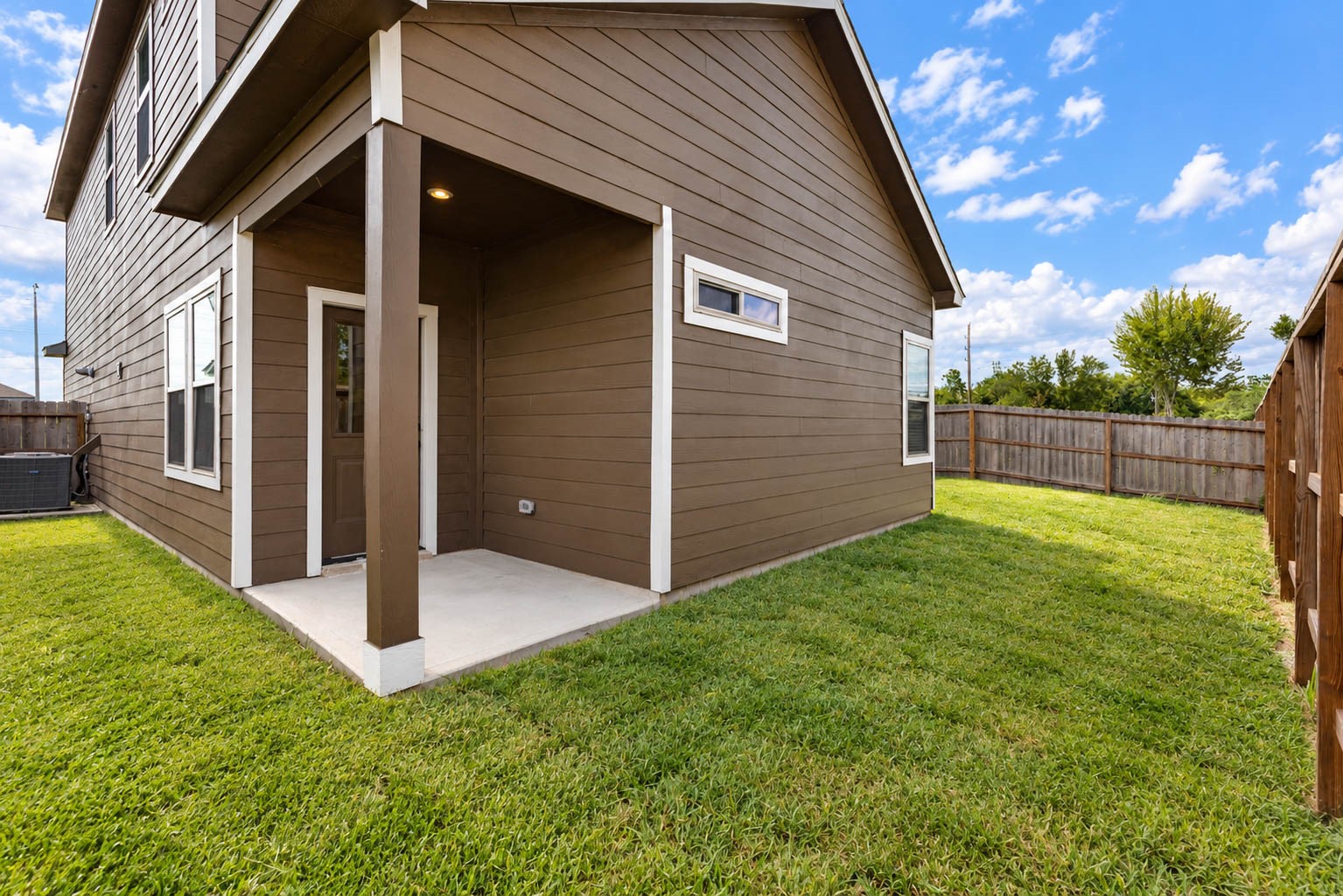 The back of the home features a covered patio with a recessed light, a perfect spot for a morning coffee or weekend barbecue rain or shine. The fenced backyard gives pets and kids a safe place to play, and the open lawn has room for a garden, play set or outdoor seating. A back door opens directly into the home for easy indoor-outdoor living.