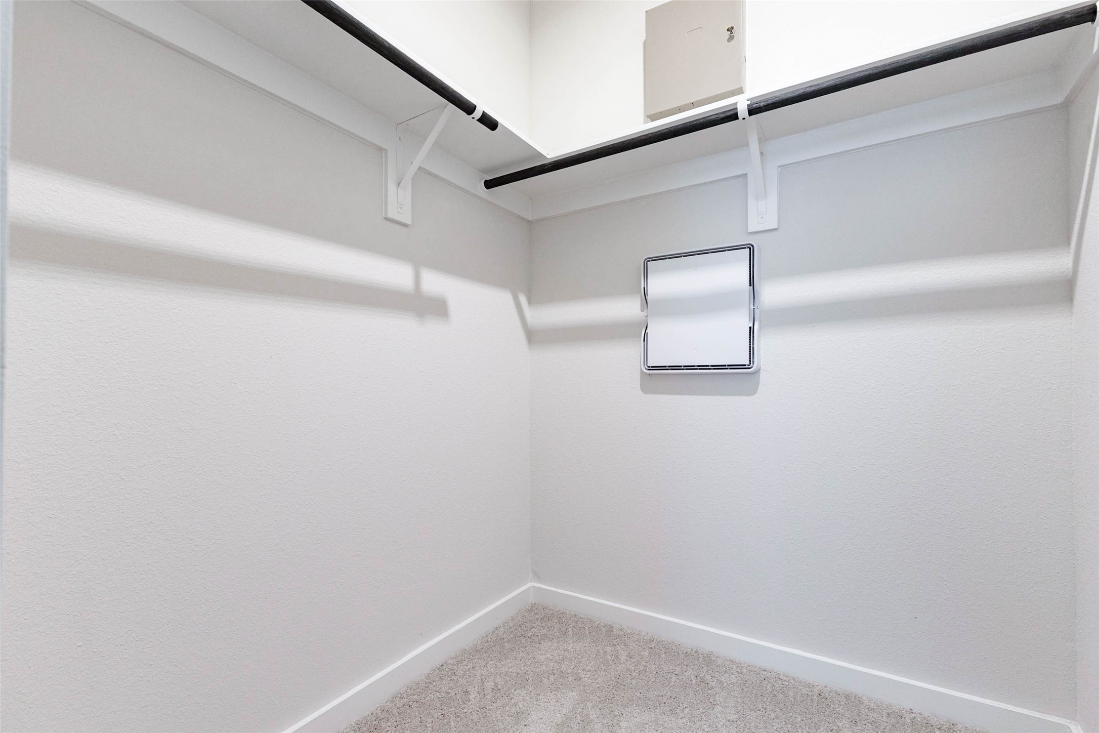 The walk-in closet attached to this bedroom offers a full-length hanging rod, a high shelf and room for dressers or storage bins. Soft carpet underfoot and a bright overhead light make it easy to see everything at a glance. Having this much storage in a secondary bedroom is a real plus for roommates, guests or a growing family that is always running out of closet space.