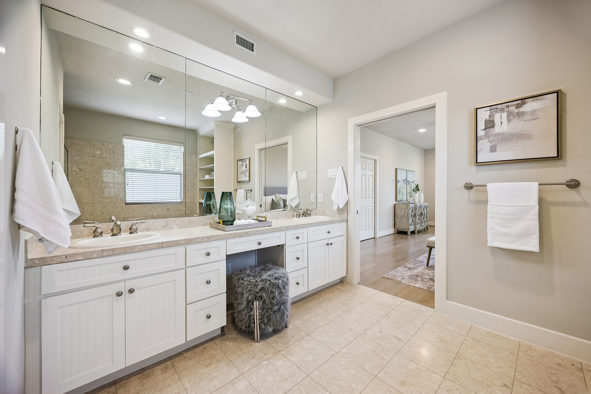 Primary bath with long vanity, abundant cabinetry and large wall mirror.