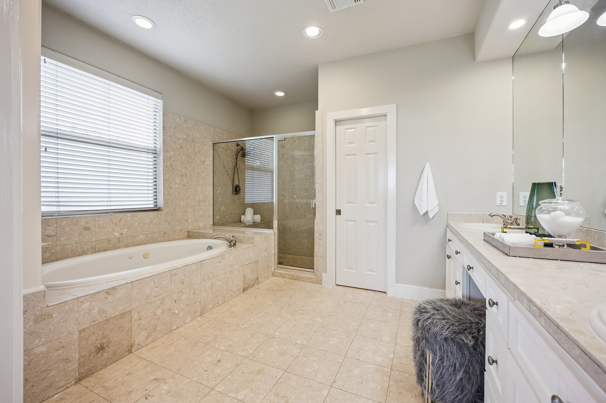 Primary bath with soaking tub, separate shower and extensive vanity space.