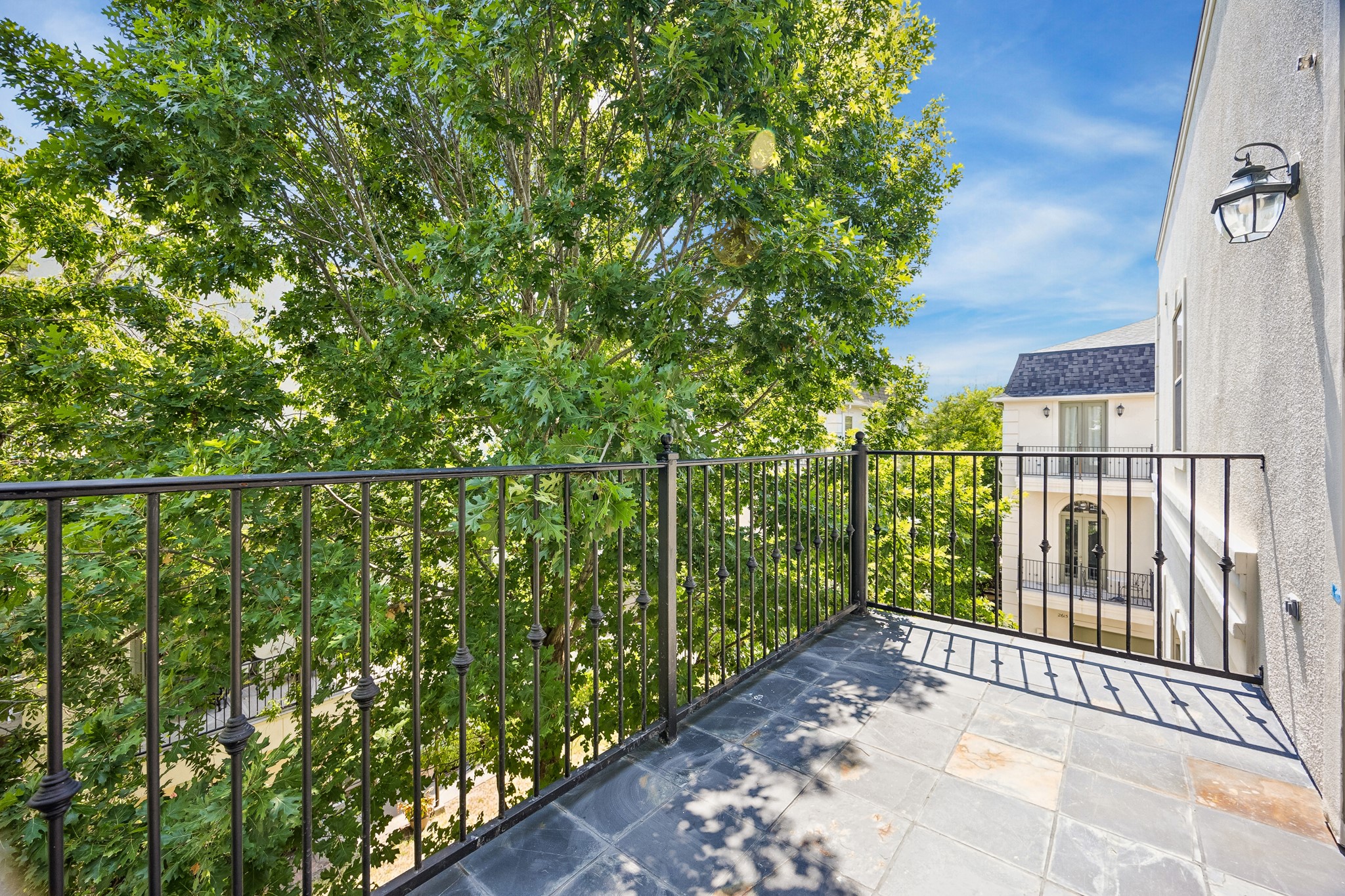 Private balcony off the primary bedroom overlooking the tree-lined surroundings.