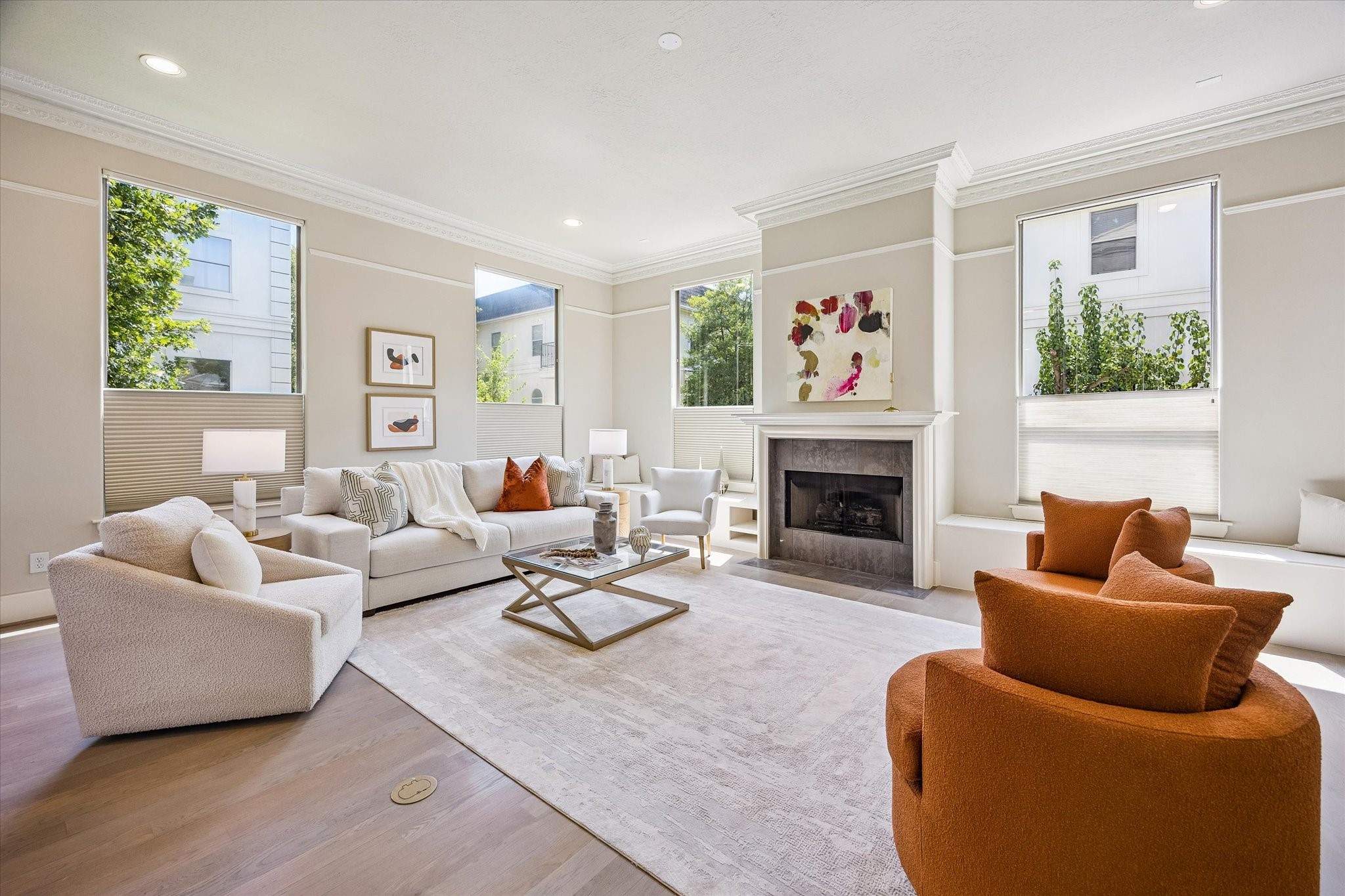 Inviting living area centered around a fireplace, flanked by built-in storage bench seating and framed by refined millwork and expansive windows.