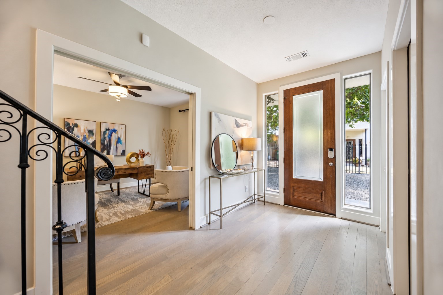 Welcoming entry with a glass front door, sidelights and a view into the first-floor bedroom. Access to the 2-car attached garage, utility area and storage room are to the right.