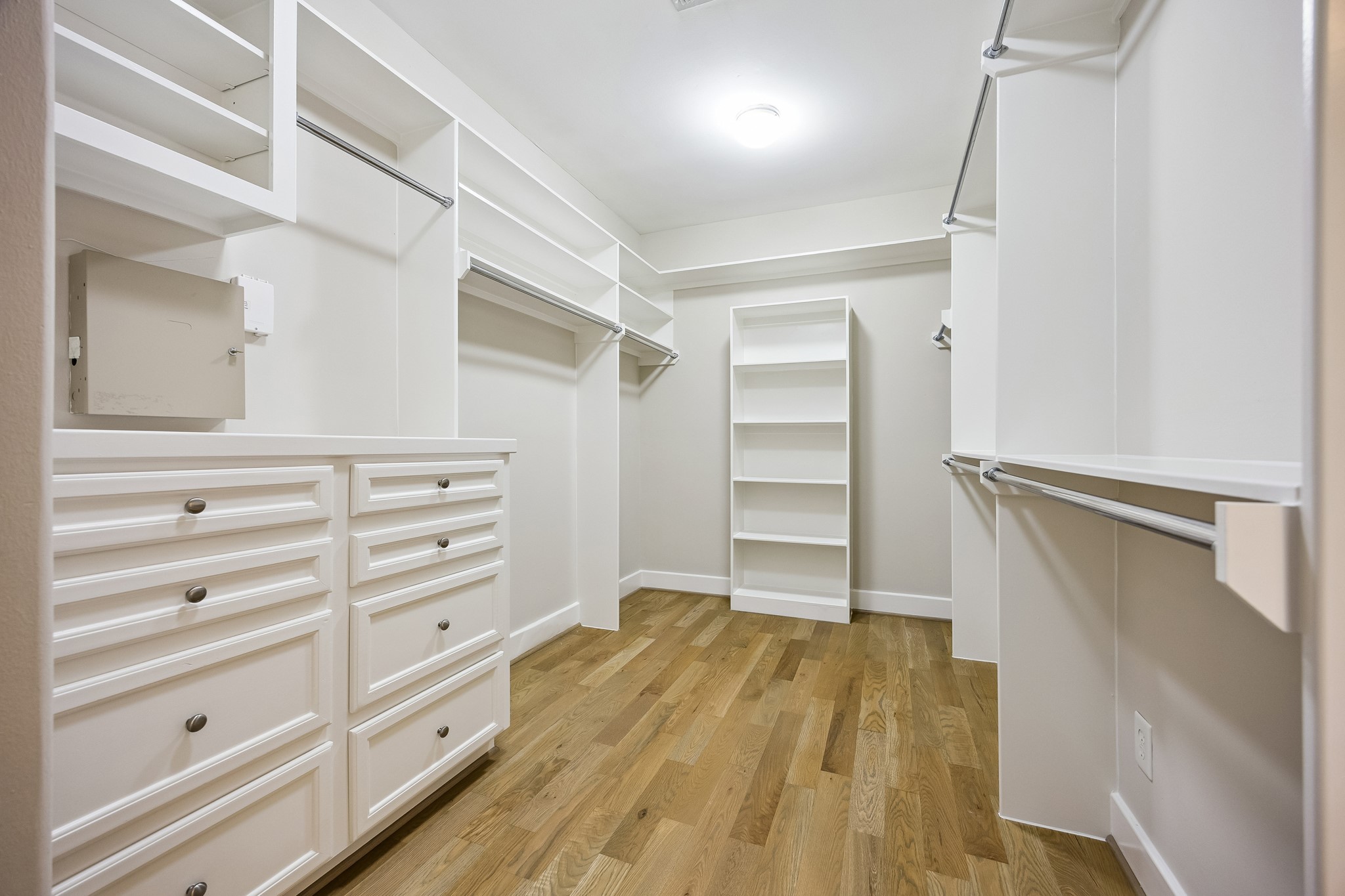 Generous primary walk-in closet with built-in drawers, shelving and hanging space.