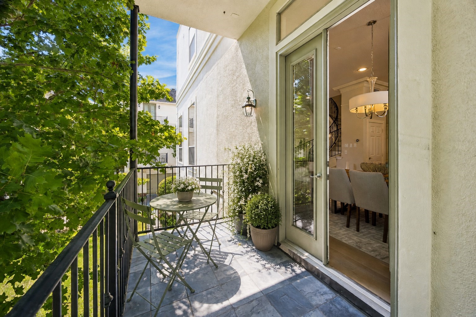 Dining-area balcony offering a shaded outdoor space surrounded by mature trees. Photo has been virtually staged.