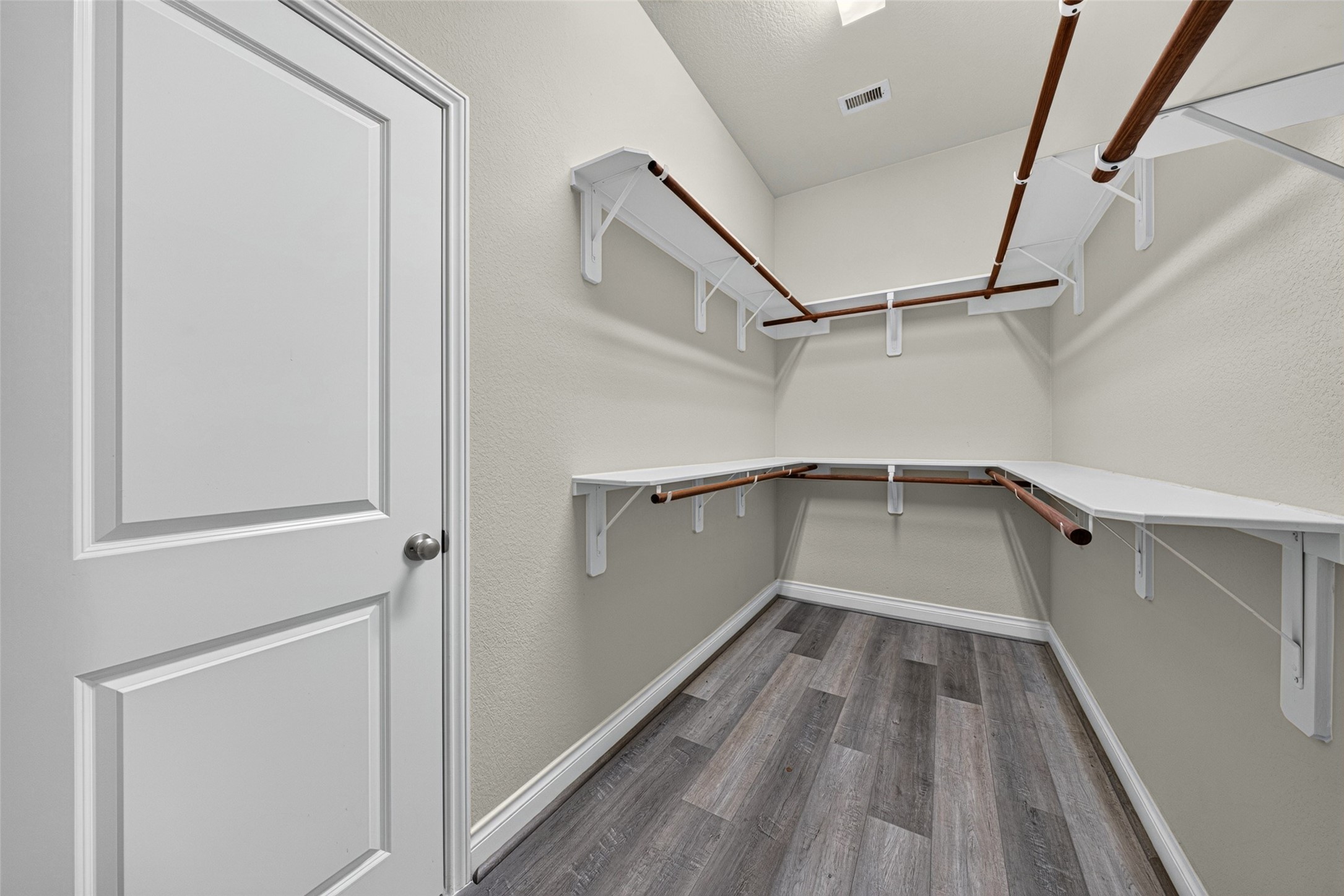 Expansive walk-in closet in the primary suite with custom shelving to keep family wardrobes organized.