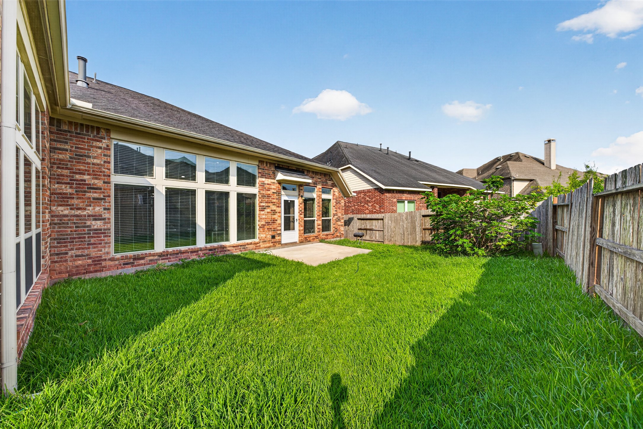 Expansive backyard with lush green grass, offering endless room for children, pets, and outdoor fun.