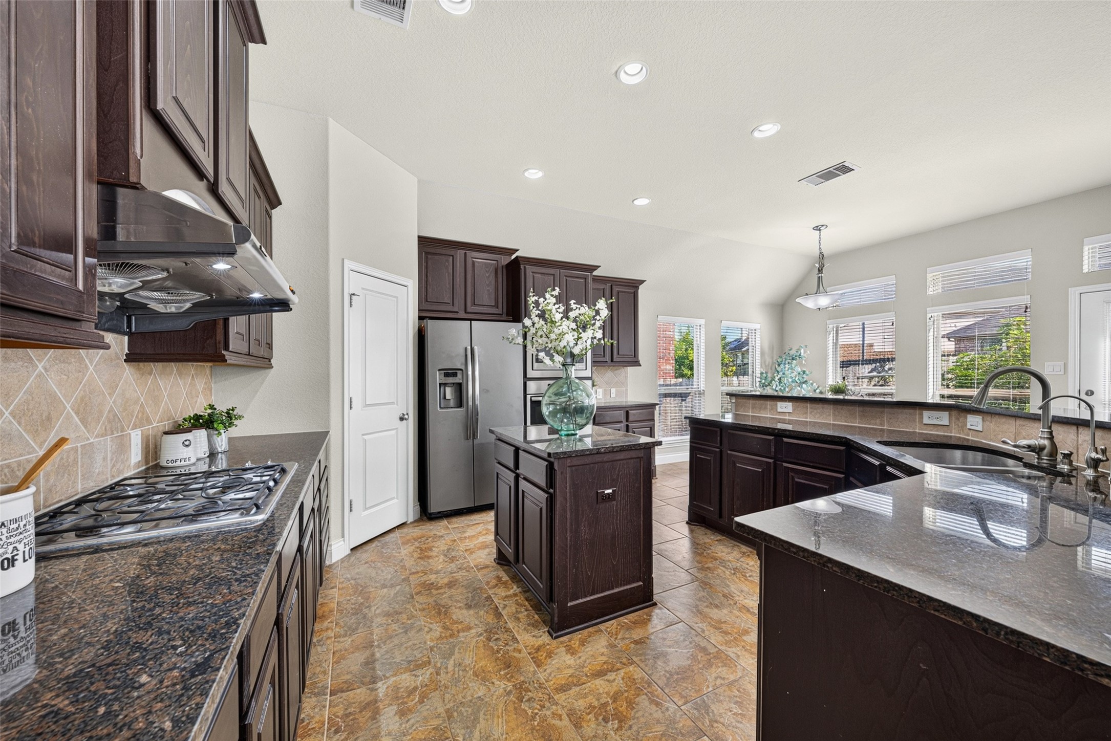 Gourmet kitchen featuring custom-built cabinetry, wide countertops, and sleek stainless steel appliances.