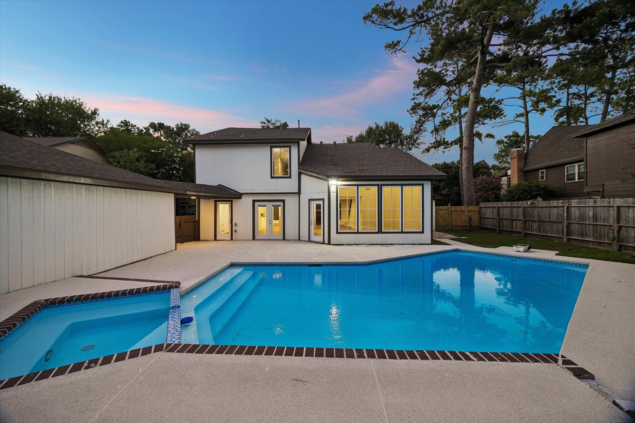 Refurbished pool and deck area featuring a resurfaced pool, updated decking, and exterior lighting  perfect for Houston summers. Professionally refreshed and move-in ready.
