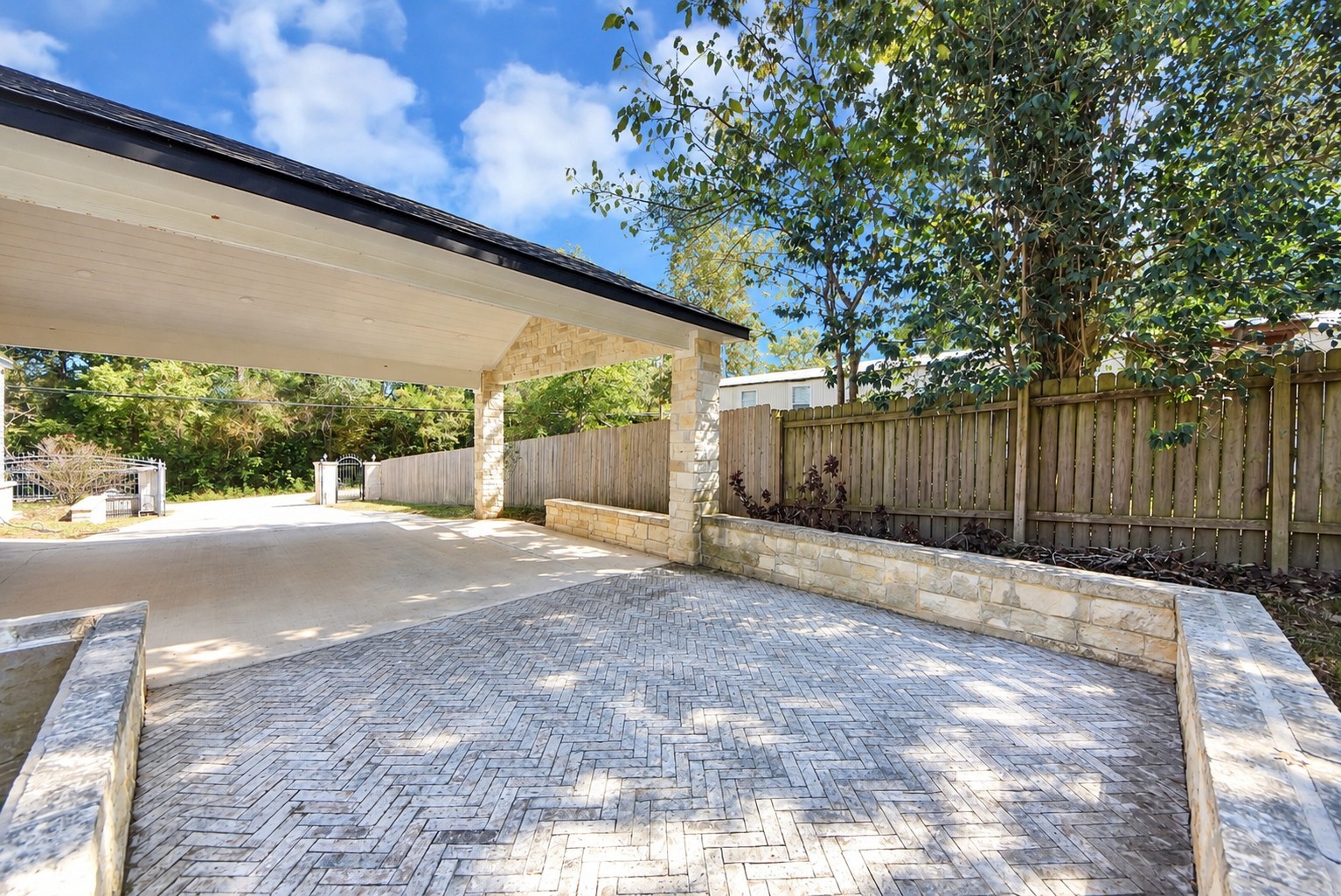 Spacious open-air paver patio with stone accents.