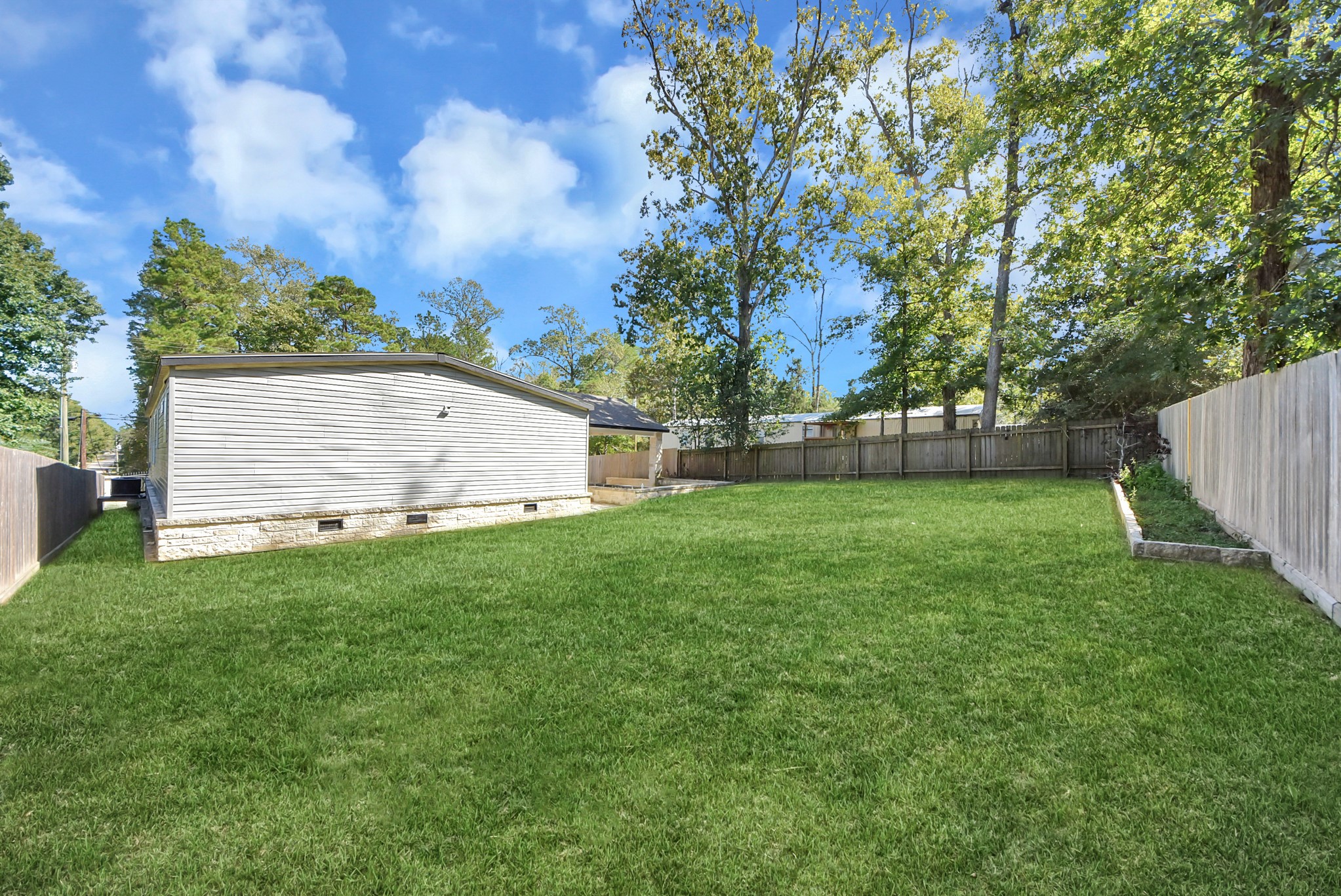 Spacious backyard with lush greenery.