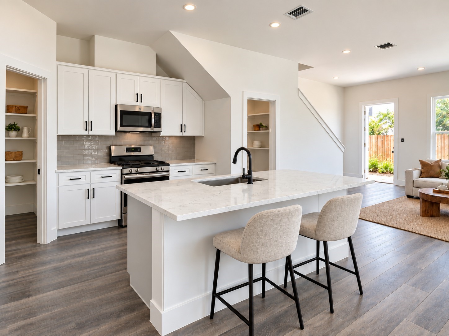 Experience the beauty of open-concept living in this thoughtfully designed kitchen and adjoining living space. The kitchen showcases white shaker-style cabinetry, stainless steel appliances, a stylish gray tile backsplash, and a generous island with stone-look countertops. Matte black fixtures provide contemporary contrast, while comfortable island seating creates a casual gathering spot. These photos have been virtually rendered for visual reference. Experience the beauty of open-concept living in this thoughtfully designed kitchen and adjoining living space. The kitchen showcases white shaker-style cabinetry, stainless steel appliances, a stylish gray tile backsplash, and a generous island with stone-look countertops. Matte black fixtures provide contemporary contrast, while comfortable island seating creates a casual gathering spot. These photos have been virtually rendered for visual reference.