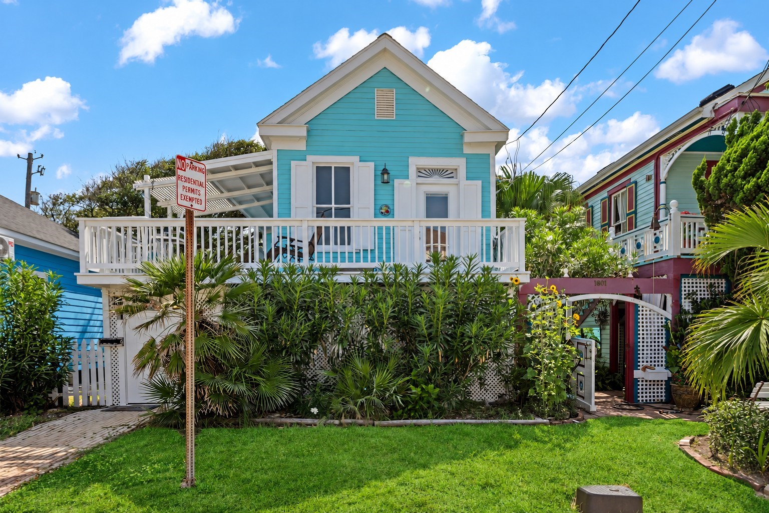 Charming coastal cottage with an inviting elevated front porch, tropical landscaping, and bright island-inspired exterior. Located approximately a block and a half from the beach, offering easy access to the Seawall, Gulf, dining, and nearby Galveston attractions.