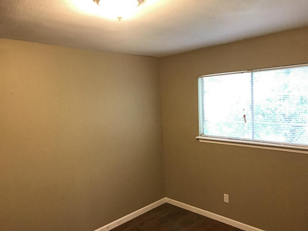 Bedroom has large bright windows.