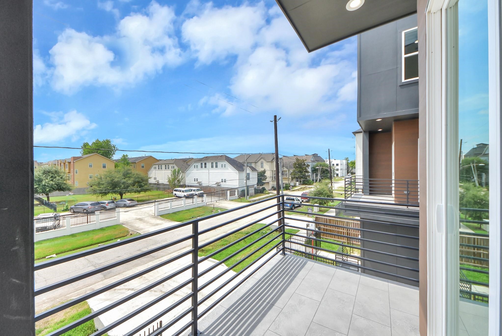 Private balcony offering open neighborhood views and sleek modern railings.