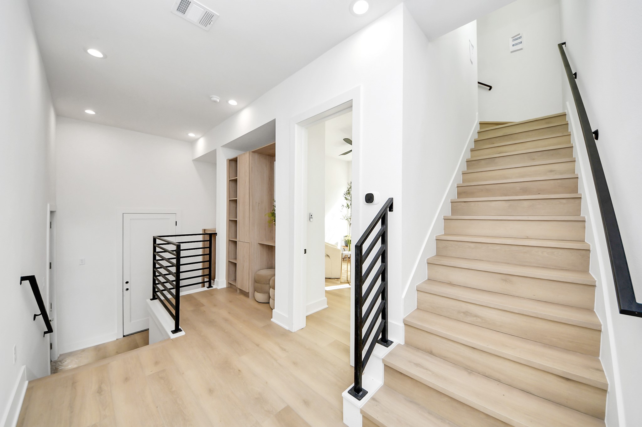 Open stair landing with sleek black railings and custom built-in storage.