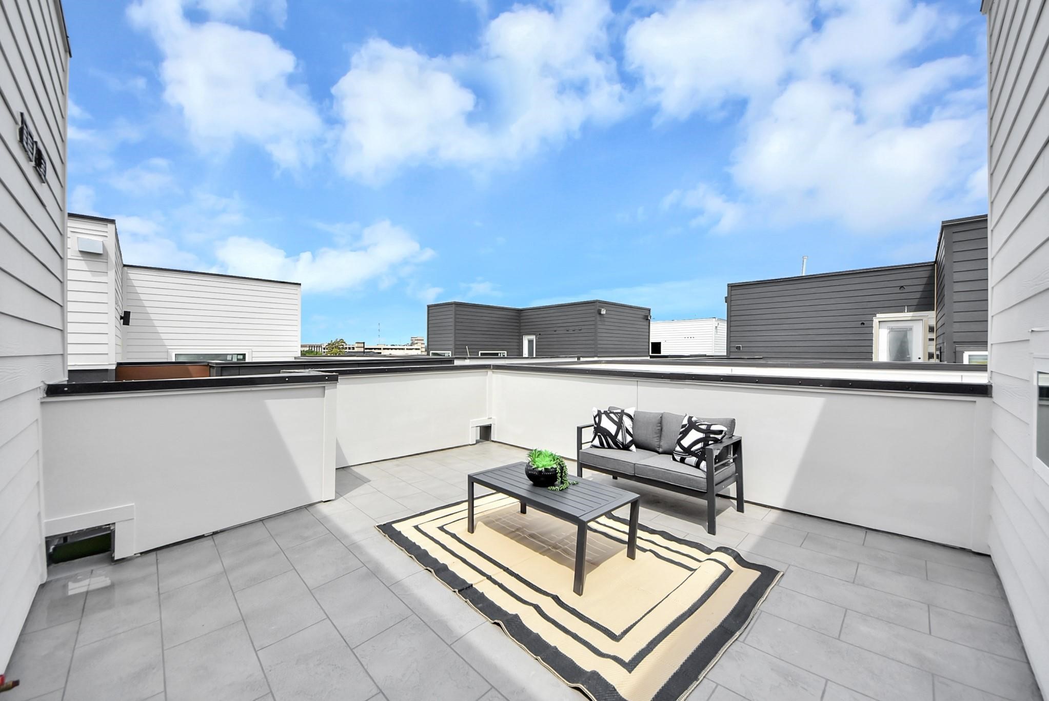 Spacious rooftop terrace with outdoor seating and open views.