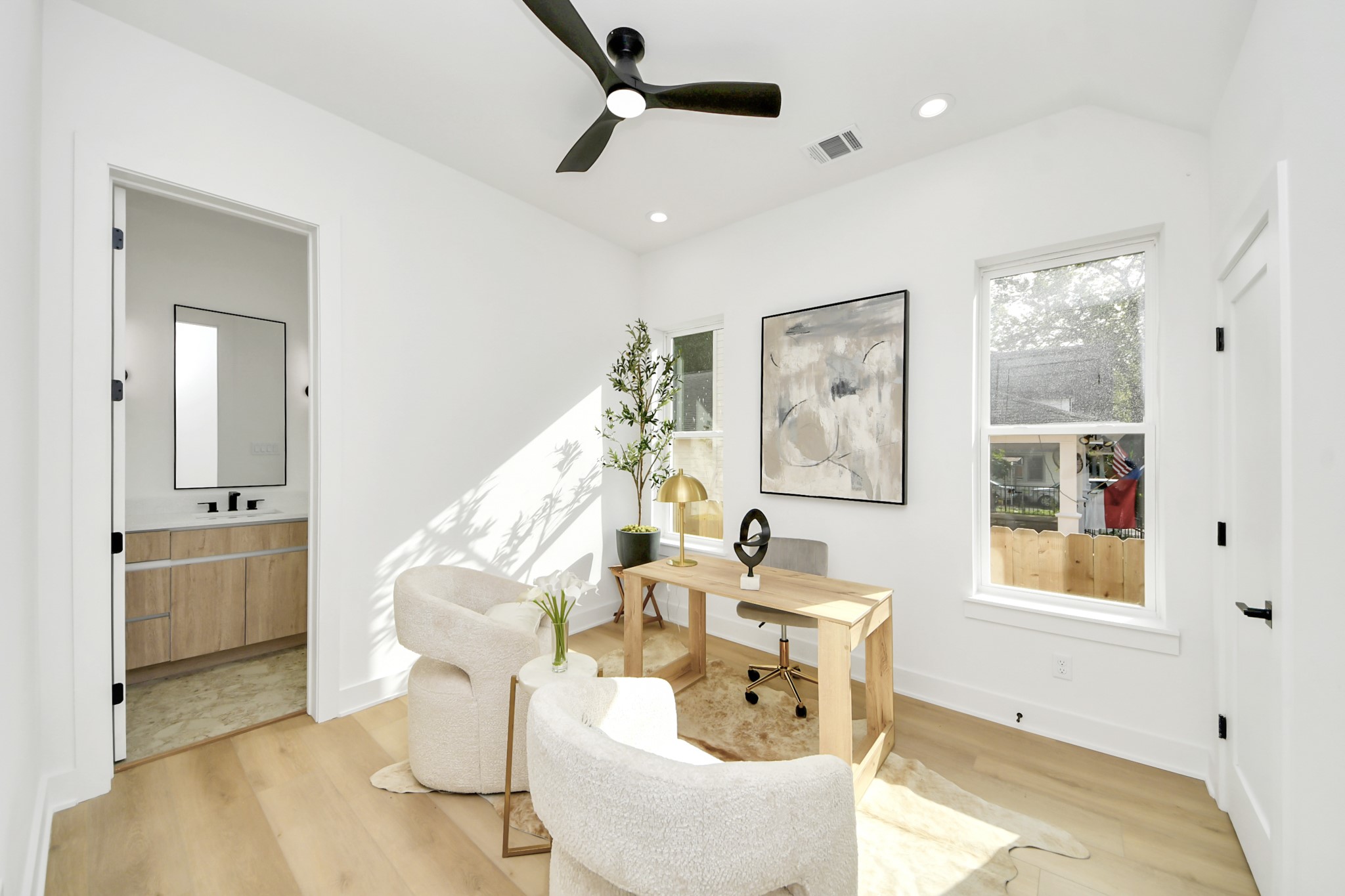 Home office with a dedicated workspace, seating area, and convenient access to a full bathroom.