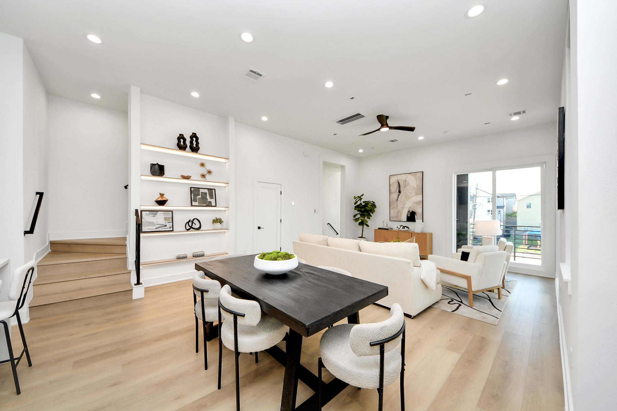 Spacious second-floor dining and living area with custom shelving and direct access to the balcony.