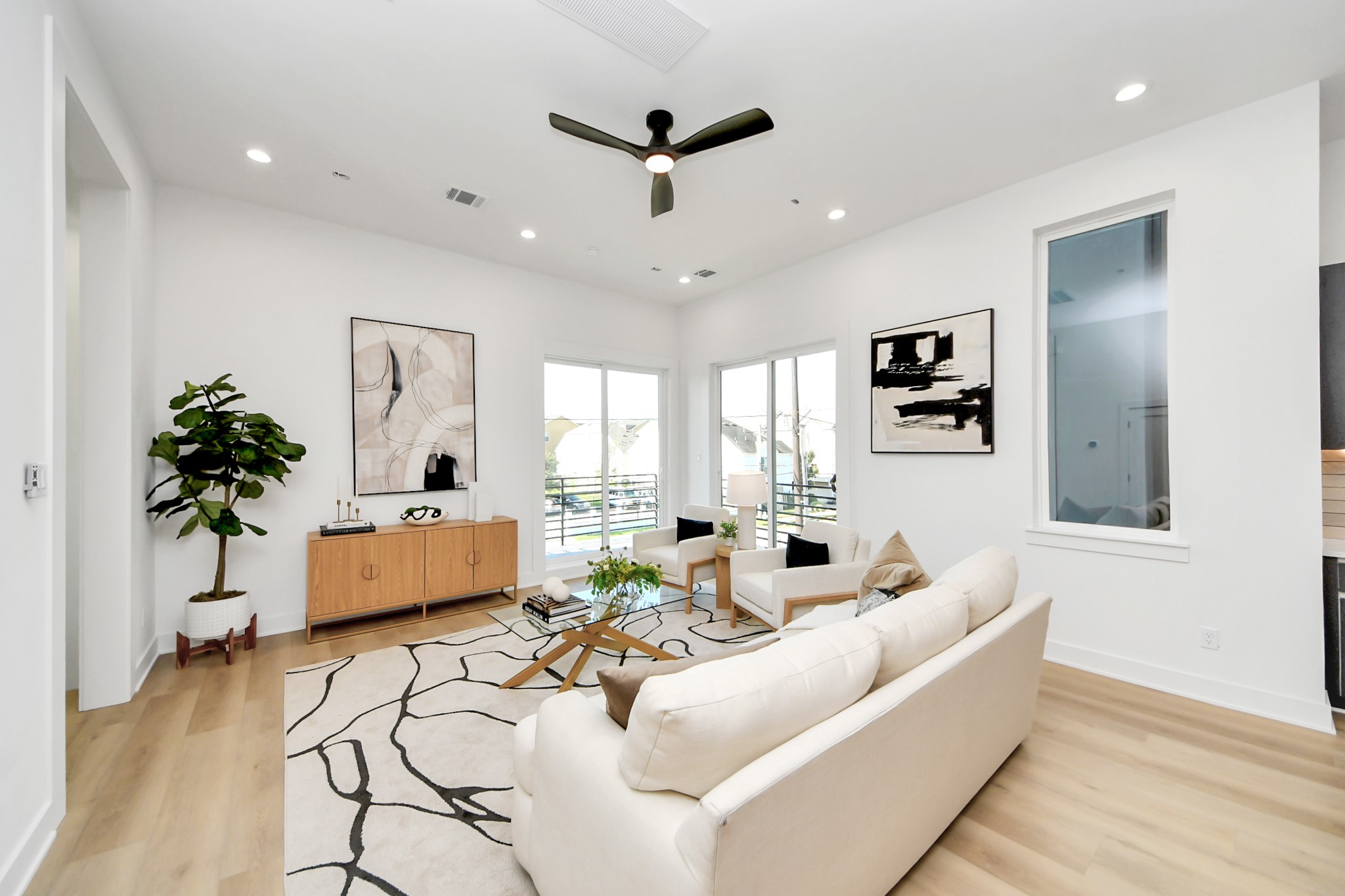Inviting living area filled with natural light and complemented by contemporary finishes and light wood flooring.