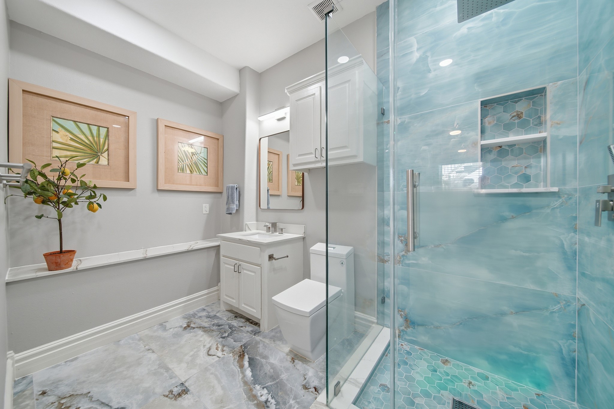 Pamper visitors in a fully finished, modern bathroom with a custom walk-in shower.