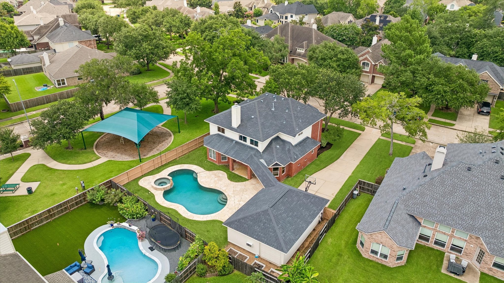 An aerial view showcases the home's private pool, detached garage, and prime location next to the neighborhood pocket park.