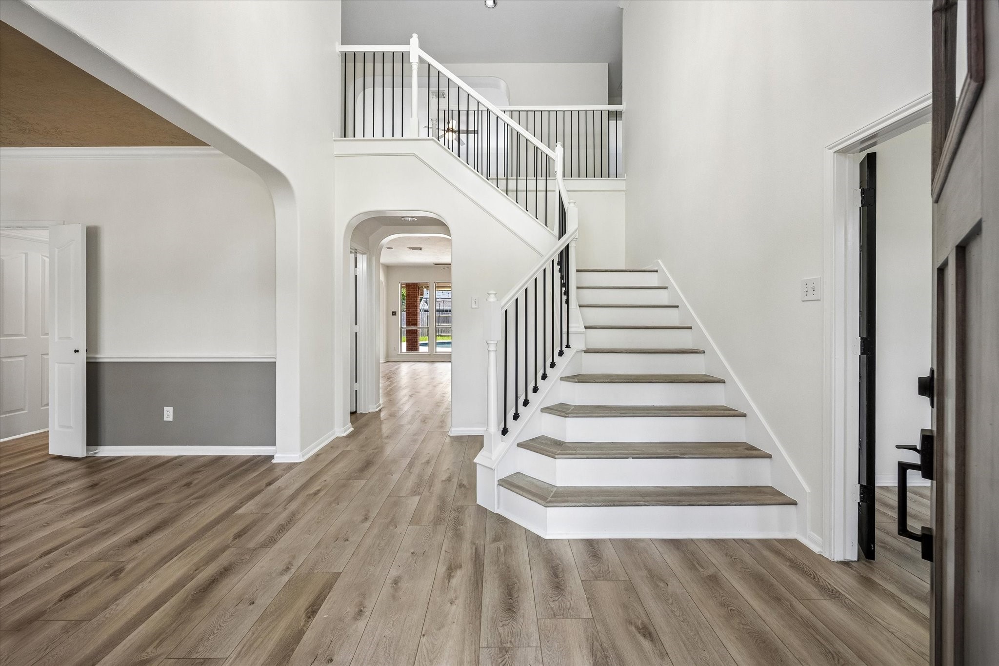 The dramatic two-story foyer welcomes you with soaring ceilings, a sweeping staircase, and durable luxury vinyl plank flooring.