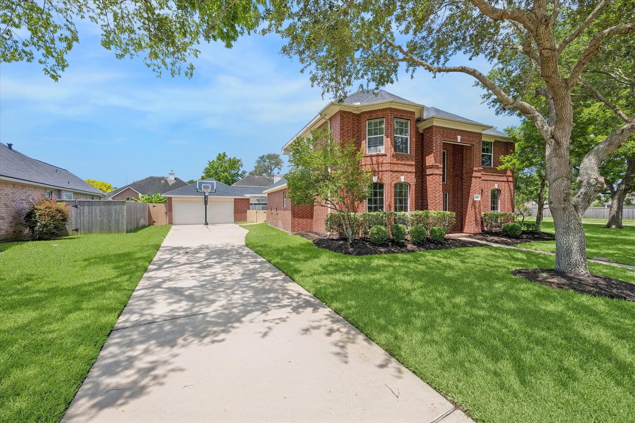 The extended driveway leads to a detached garage, offering ample parking and added privacy.