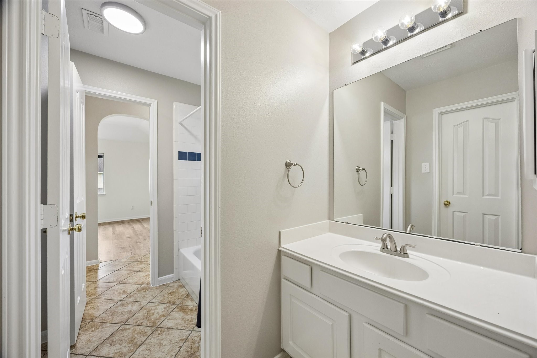 Another view of the upstairs vanity highlights its functional layout and shared access.