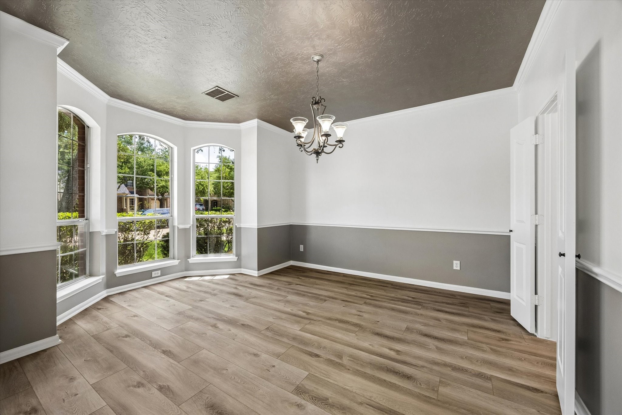 The formal dining room offers elegant windows, crown molding, and plenty of space for hosting family and friends.