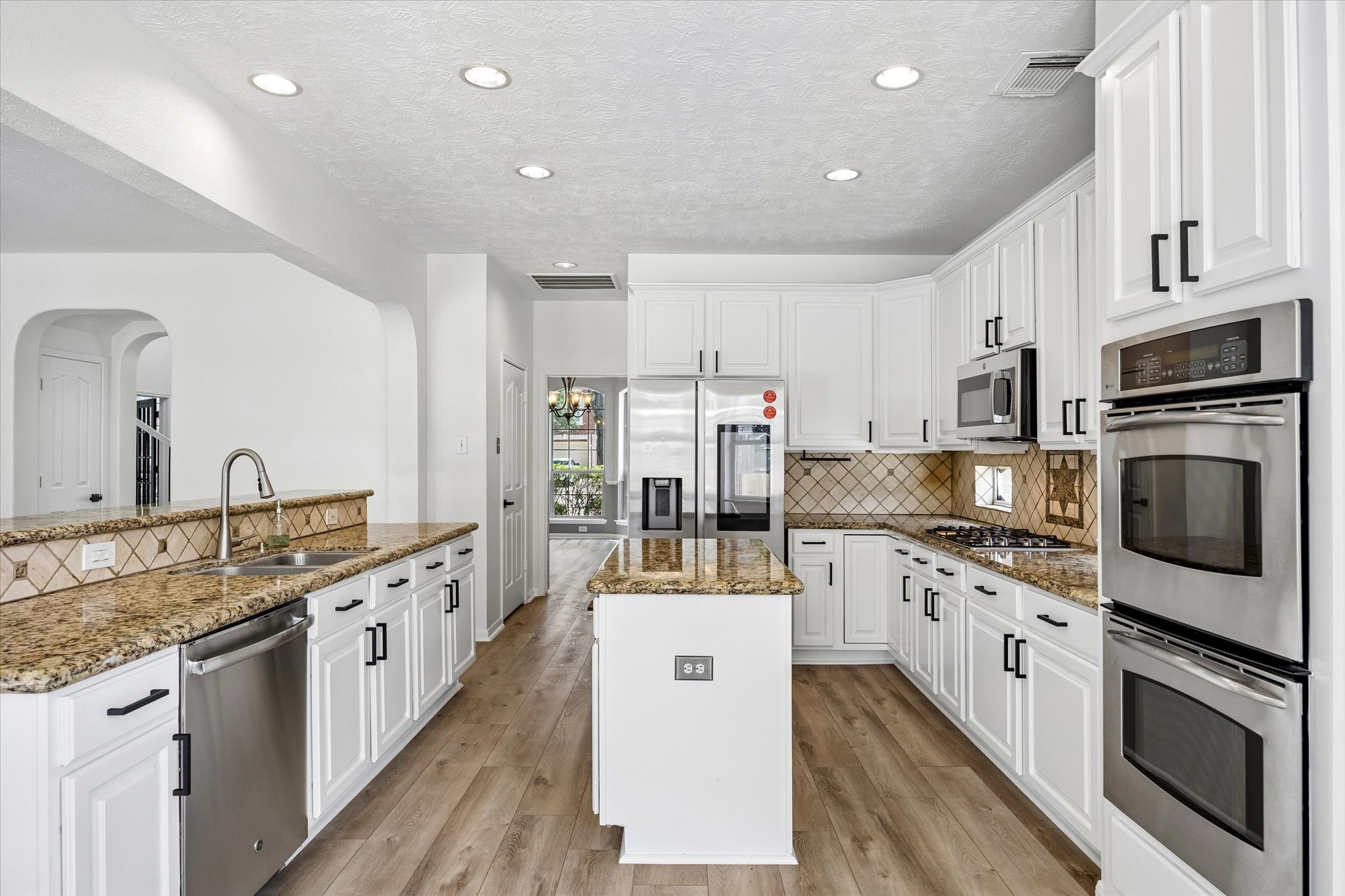 The remodeled kitchen showcases granite countertops, abundant cabinetry, stainless steel appliances, and a center island.