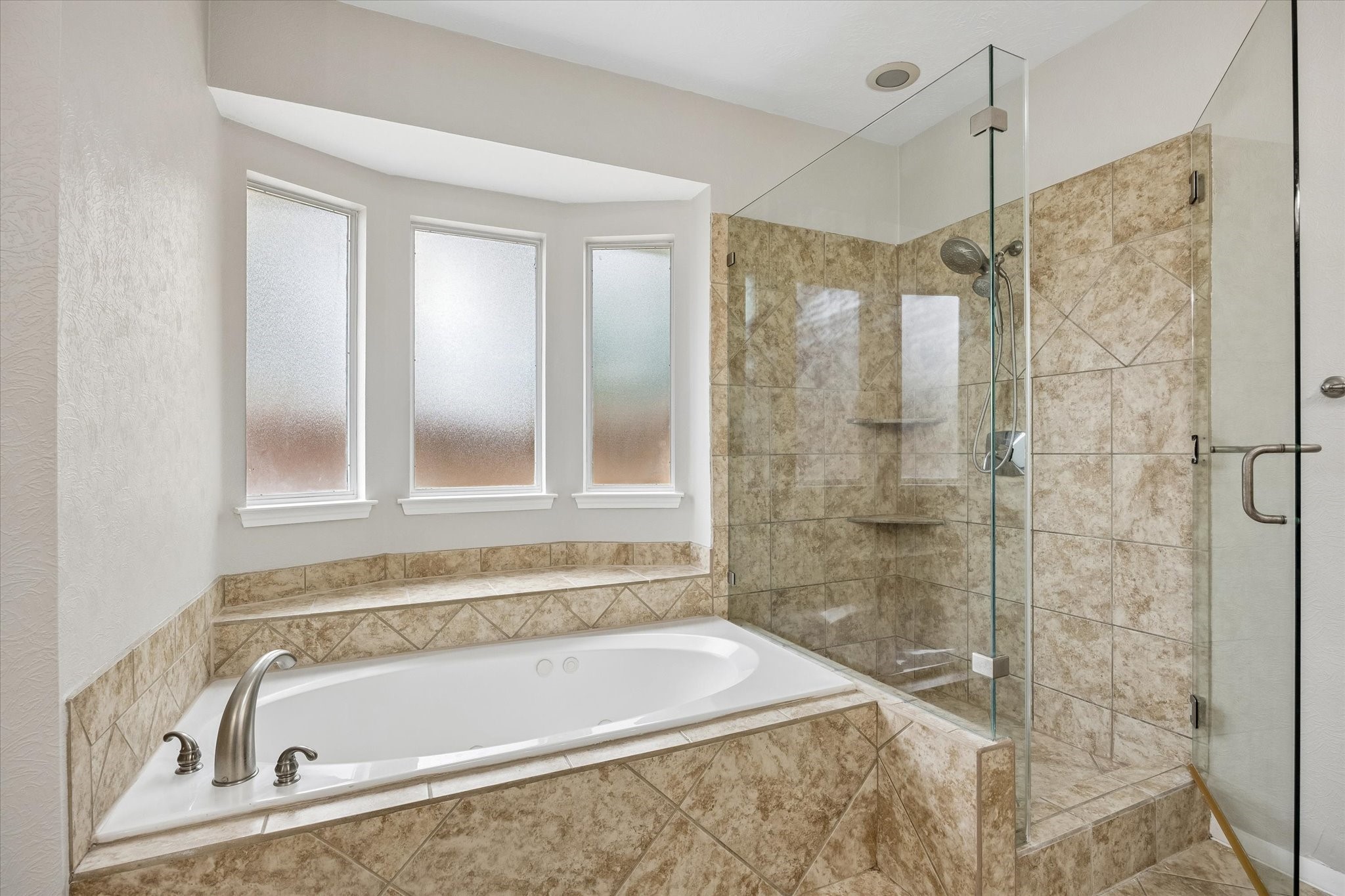 Relax in the oversized soaking tub or enjoy the separate frameless glass walk-in shower.