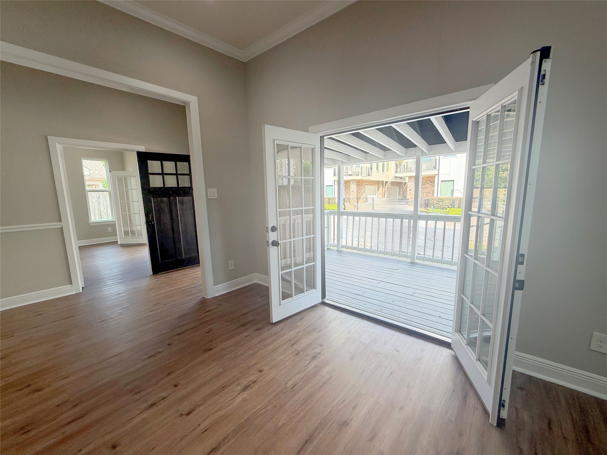 Wide-open French doors beautifully frame the covered porch, extending the living area's appeal beyond the interior and creating an ideal setting for indoor-outdoor entertaining.
