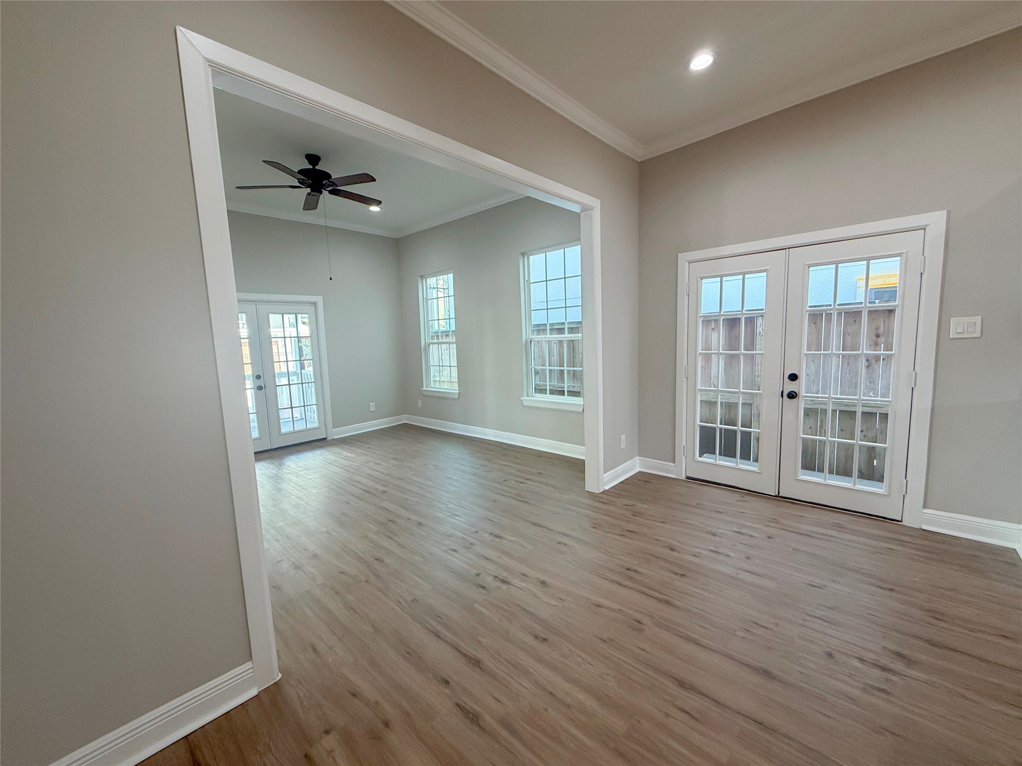 Open dining area with French doors providing natural light and access to a small exterior porch, complemented by a wide opening to the adjoining living room.