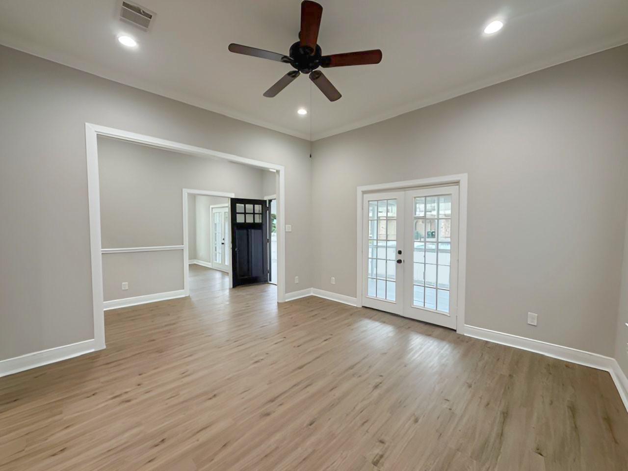 This perspective highlights the room's generous proportions, high ceilings, and natural light, with an open transition to the front entry.