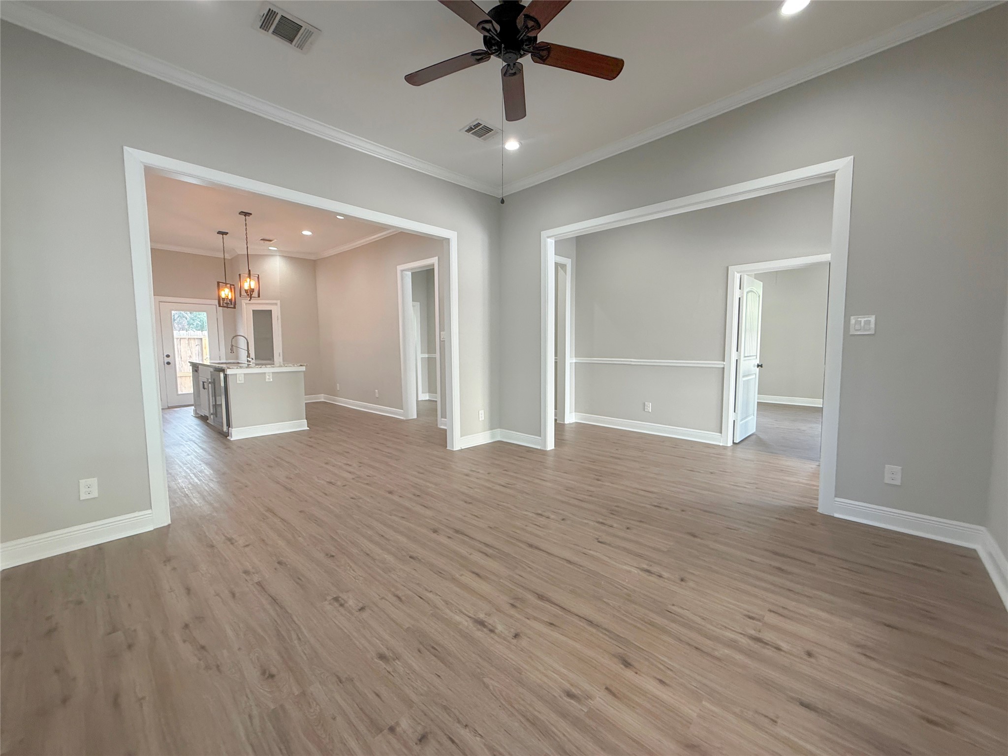 Wide openings create a seamless connection between the living room, kitchen, and adjoining interior spaces, providing an open, versatile floor plan.