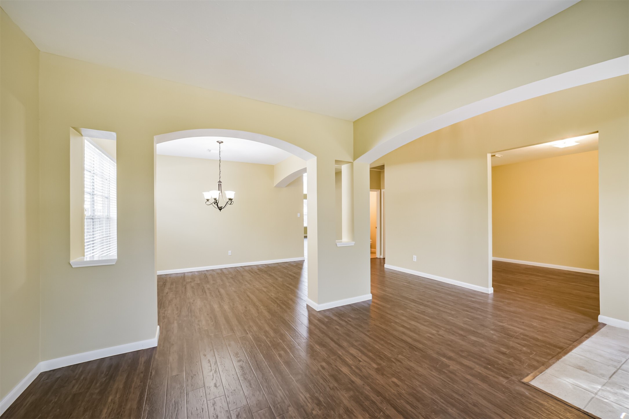 Arched openings connect the dining area to the front flex room.